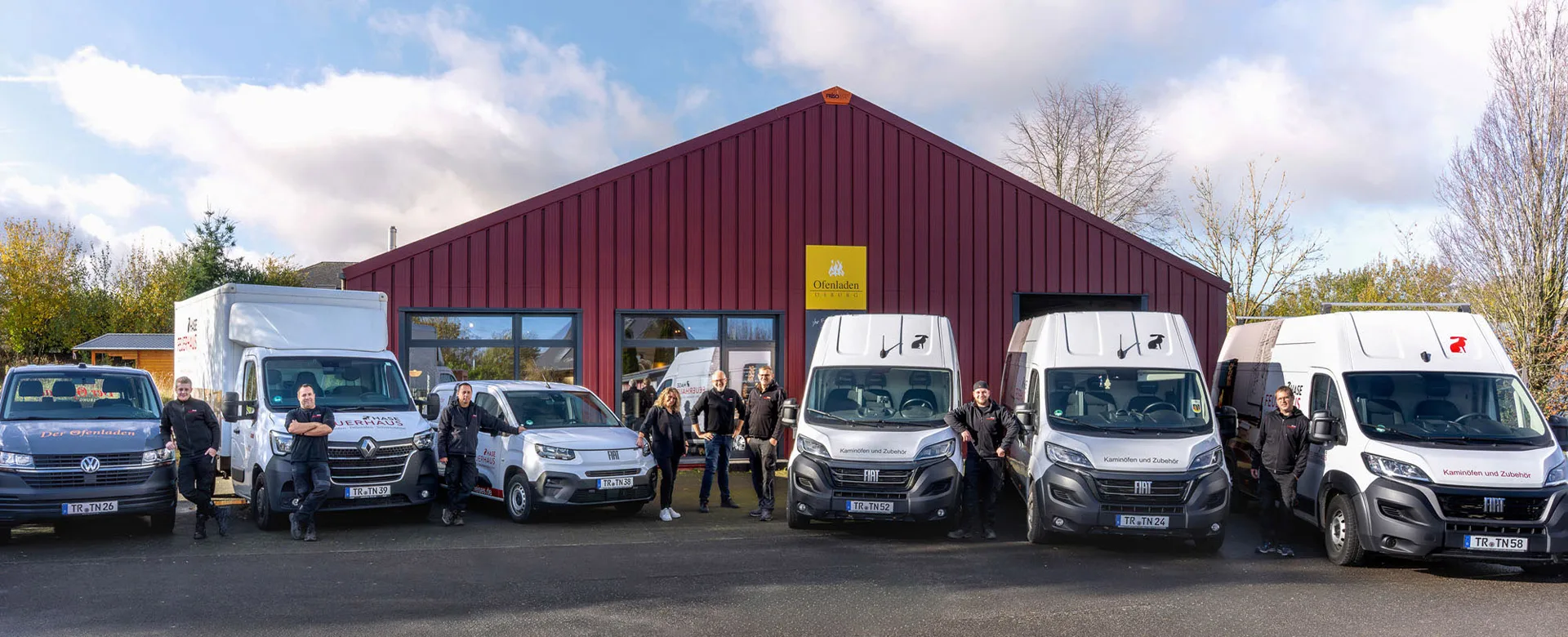 Ofenladen Osburg das gesamte Team draussen vor der Fahrzeugflotte mit Service Fahrzeugen