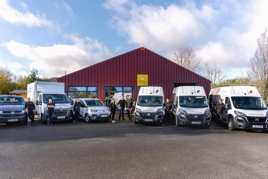 Ofenladen Osburg das gesamte Team draussen vor der Fahrzeugflotte mit Service Fahrzeugen